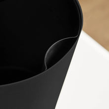 Black self-watering planter interior wall with integrated channel and curved rim