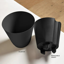 Black self-watering planter with removable insert shown beside the pot