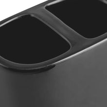 Close-up of black ceramic toothbrush holder slot opening, glossy finish