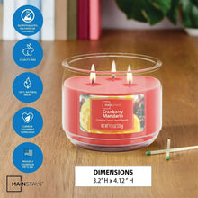 Mainstays cranberry mandarin 3-wick candle in a clear glass jar on a table