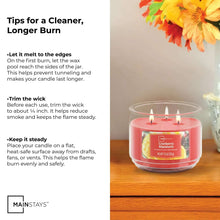 Mainstays cranberry mandarin candle in a clear glass jar with 3 lit wicks