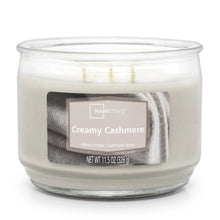 Creamy cashmere scented candle in clear glass jar, three unlit wicks, front label