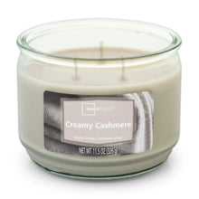 Creamy cashmere scented candle in clear glass jar, three unlit wicks, centered label