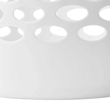 Close-up of white plastic laundry hamper with oval ventilation holes