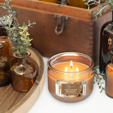Caramel macchiato scented 3-wick candle in clear glass jar with centered label