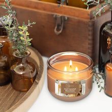 3-wick scented candle in clear glass jar with caramel wax and front label