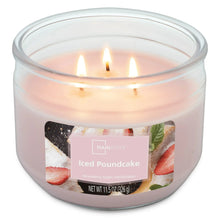 Pink 3-wick scented candle with three lit wicks in clear glass jar
