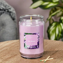 Lilac scented glass jar candle with burning wick and Lilac Breeze label