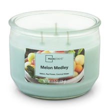 Teal wax candle in clear glass jar with three wicks and Melon Medley label