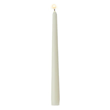 Ivory taper candle with lit wick