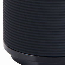 Black plastic toothbrush holder with ribbed texture and glossy rim
