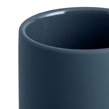 Blue ceramic toothbrush holder close-up of the rounded rim and textured surface.