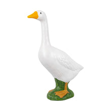 White garden goose statue with yellow beak and green base.