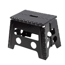Black plastic folding step stool with textured surface and cutout hand holds