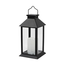 Black solar lantern with glass panels and metal handle, clear cylinder candle inside.