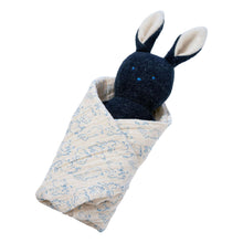 Embroidered plush bunny rattle in light patterned fabric wrap, lying sideways