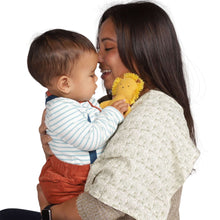 Plush lion baby rattle in mother’s arms as baby touches the toy