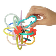 Infant loop rattle held in a hand, with multicolor rings and star grips
