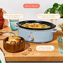 Light blue manual slow cooker with black lid and serving-ready interior