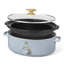 Light blue manual slow cooker with black lid, gold knob, and side handles