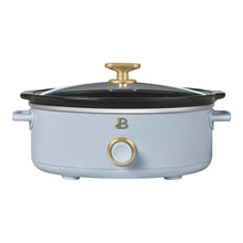 Light blue manual slow cooker with black lid and gold temperature control dial