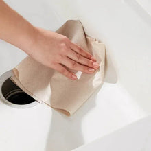 Brown 1-ply recycled paper towel sheet pulled from a roll in hand