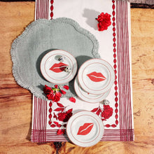 Round appetizer plates with red lip graphic and red rim, three plates shown