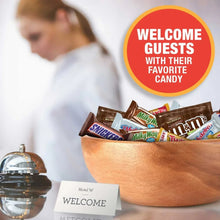 Assorted chocolate candies in wooden bowl, including Snickers, Milky Way, M&M’s, Twix