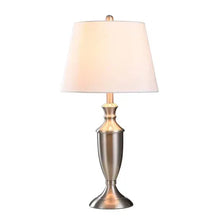 Table lamp with light peach drum shade and gold-and-silver tiered base