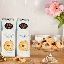 Chocolate Crunch shortbread cookie cartons with assorted cookies on a glass plate