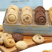 Shortbread cookie tin with assorted round cookies in clear tray, close-up