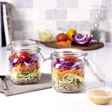 Set of 2 clear glass clamp jars with airtight lids, one opened, food inside