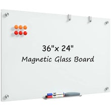 Magnetic glass whiteboard with magnets and aluminum marker tray on a white surface