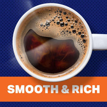 Ground coffee in a white cup with dark brewed coffee and crema bubbles
