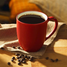 Red ceramic coffee mug filled with dark roast coffee