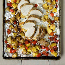 Roasted vegetables and herbs on a foil baking tray