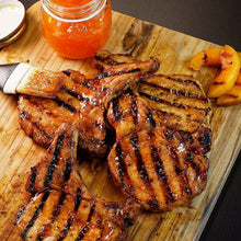 Brown sugar bourbon seasoning on grilled chicken pieces with dark charred grill marks