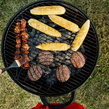 Grilled burgers, bacon, and corn on a barbecue grill