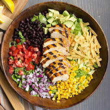 Taco toppings bowl with black beans, corn, tomatoes, onions, and grilled meat