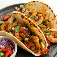 Seasoned tacos with ground meat, onions, tomatoes, herbs, and cheese in shells