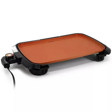 Electric grill with copper-toned griddle plate, black side handles, and heat control knobs