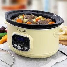 Cream electric slow cooker with black lid, pot filled with meat and vegetables
