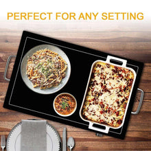 Electric warming tray with rectangular pizza dish and small bowls on open black surface