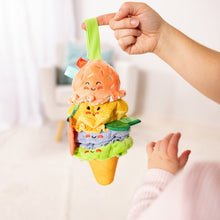 Ice cream clip-on plush toy held by a hand, with peach scoop, layered fabrics, and ribbon