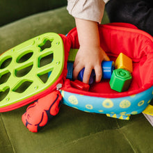 Open Take-Along shape sorter bag showing green panel and colorful shape blocks inside