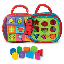 Two-sided Take-Along shape sorter activity bag with patterned panels and shape holes