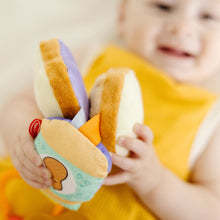 Close-up of clip-on sensory toy with bread slice face patch and orange strap