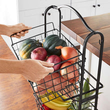 3-tier black wire standing basket with curved handle, filled with vegetables and fruit
