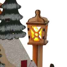 Glowing lantern on wooden post beside decorated pine tree pieces