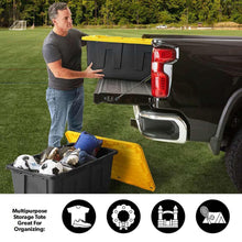 Black and yellow storage tote outdoors with lid lifted and gear inside a pickup bed